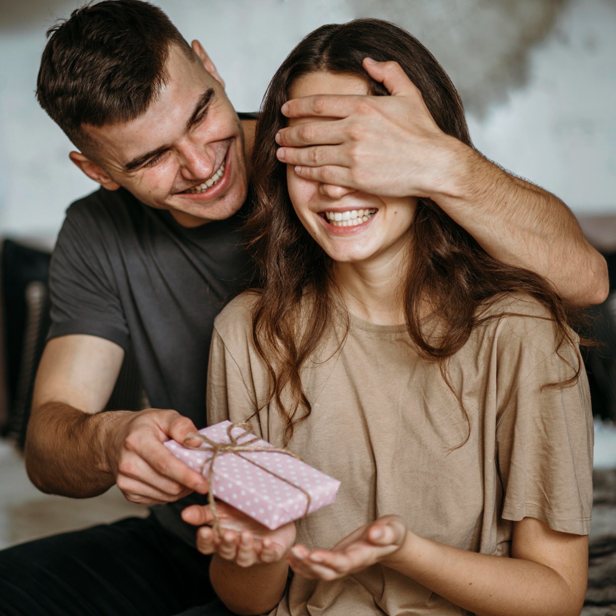 young-man-surprising-girlfriend-with-present.jpg