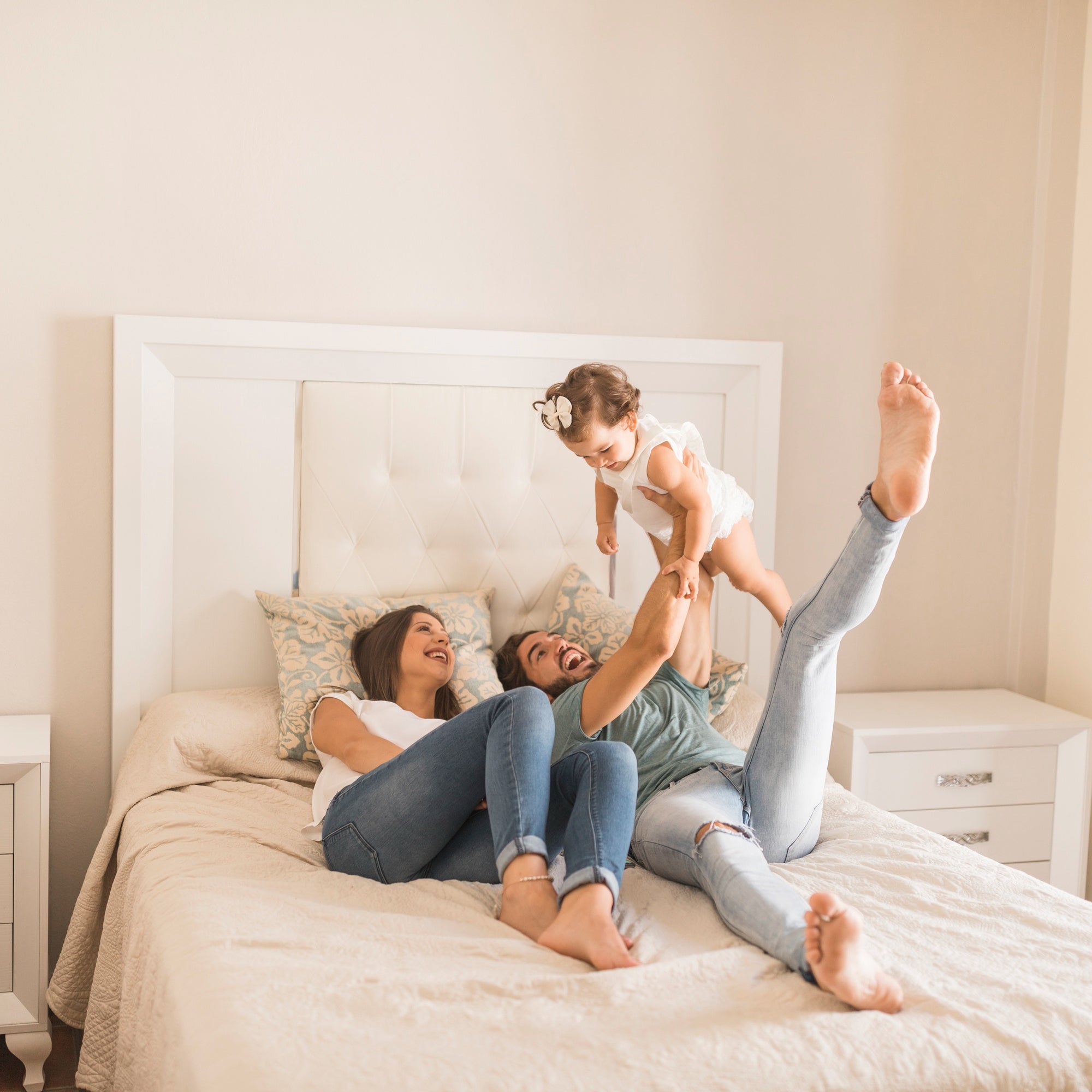 young-parents-lying-bed-lifting-daughter.jpg